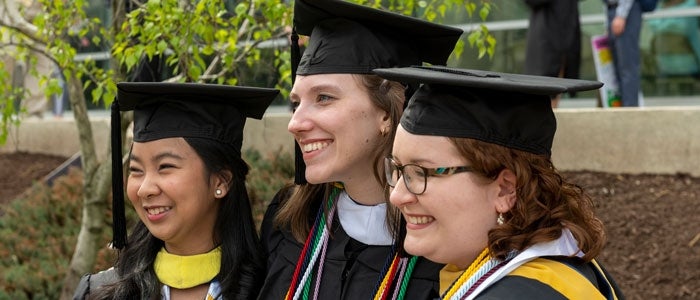 Three women grads with cap and gown